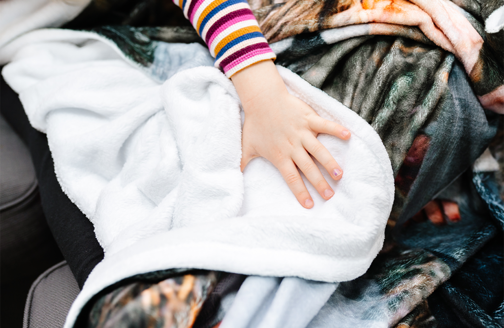 Child touches a blanket showing the sherpa texture