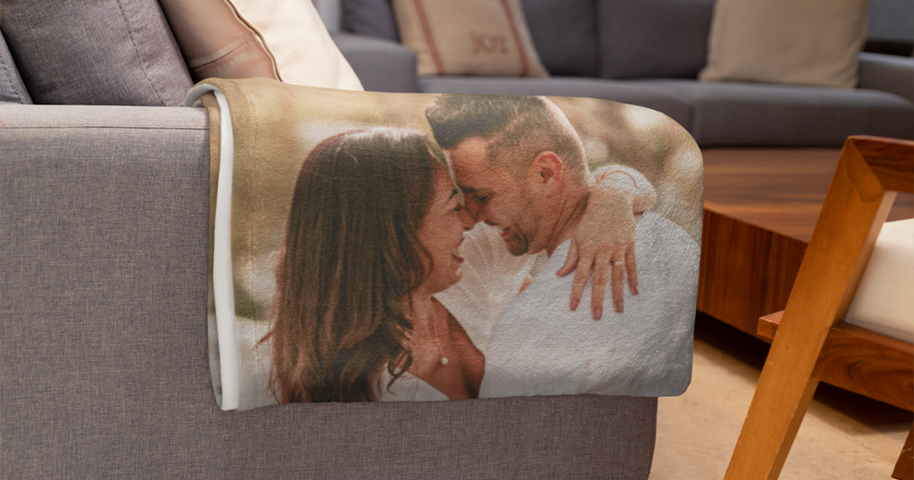 Photo blanket featuring a smiling couple laid over the arm of a couch