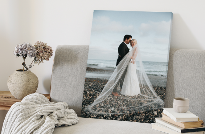 A canvas print depicting a couple on their wedding day is leaned against a chair